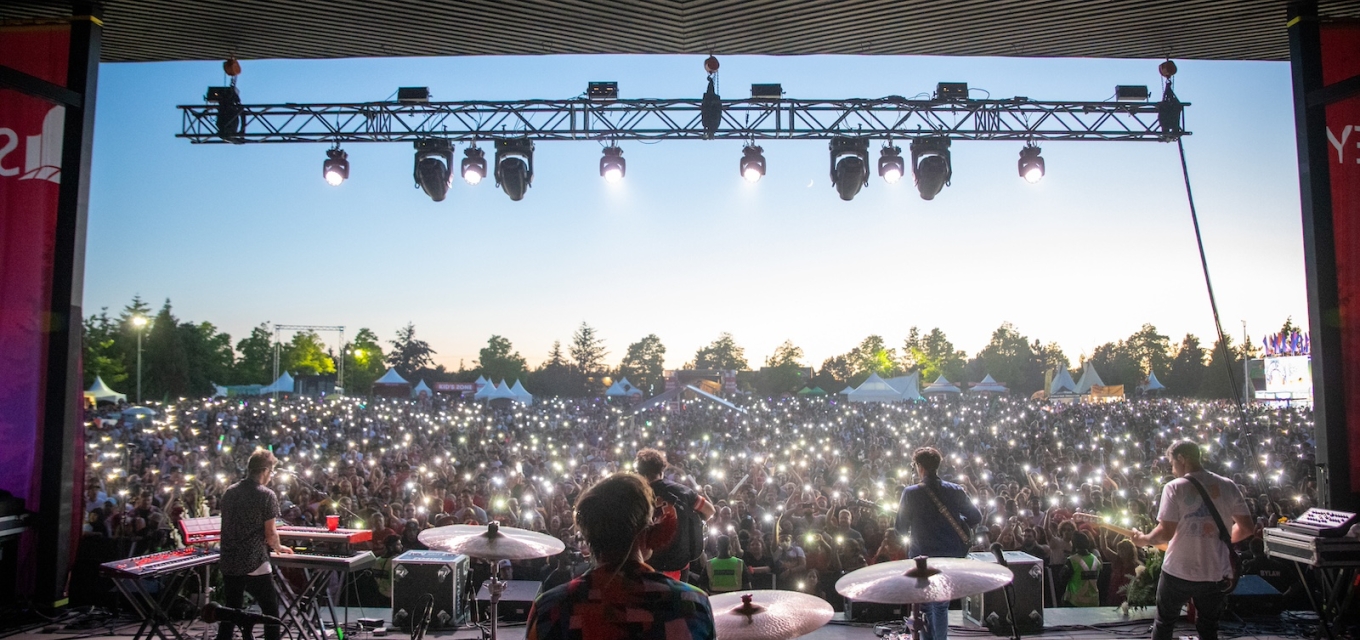 Performers on stage face large audience at Canada Day festival